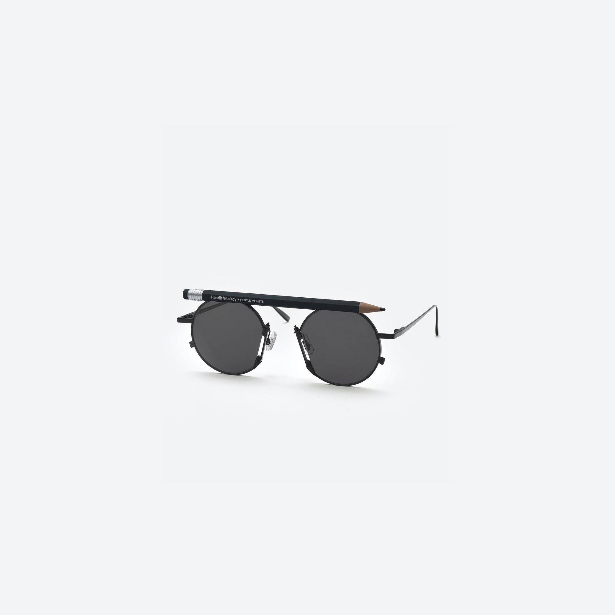 45-degree view of Gentle Monster Henrik Vibskov - Pencil Glasses Black Pen Black Metal framed Round sunglasses.