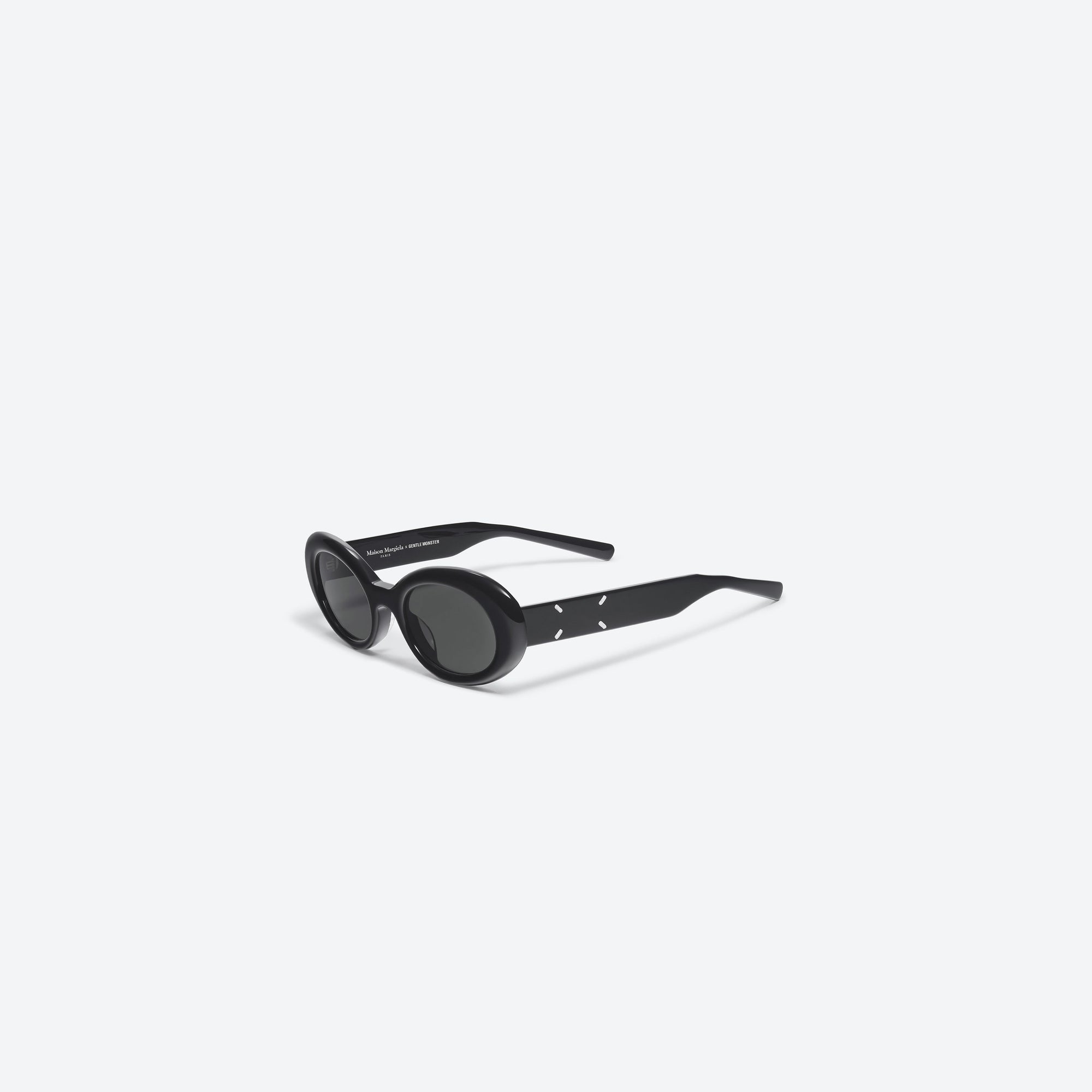 45-degree view of Gentle Monster Maison Margiela - MM005 01 Black Acetate framed Oval sunglasses.