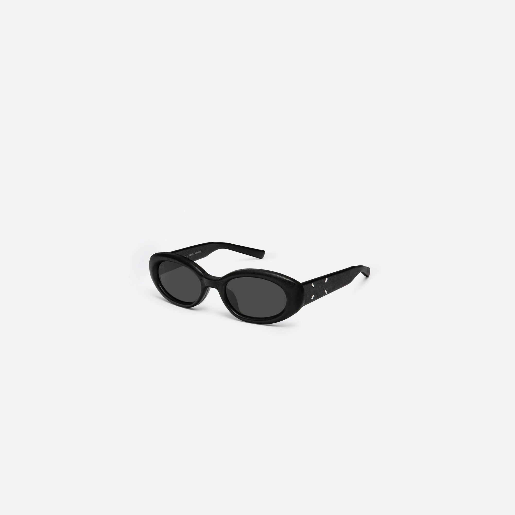 45-degree view of Gentle Monster Maison Margiela - MM107 Leather L01 Black Acetate framed Oval sunglasses.