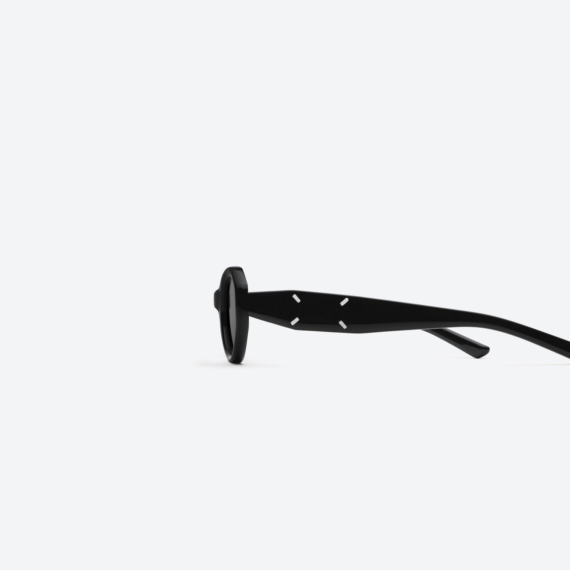 A detailed left view of Gentle Monster Maison Margiela - MM204 01 Black Acetate framed Oval sunglasses.