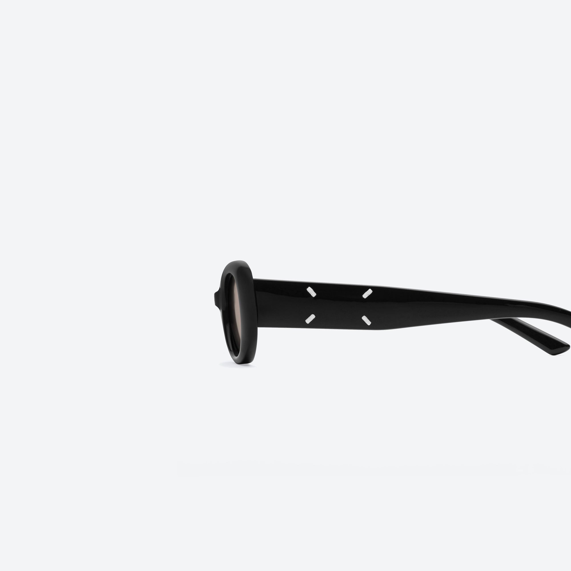 A detailed left view of Gentle Monster Maison Margiela - MM206 01(BR) Black Acetate framed Oval sunglasses.